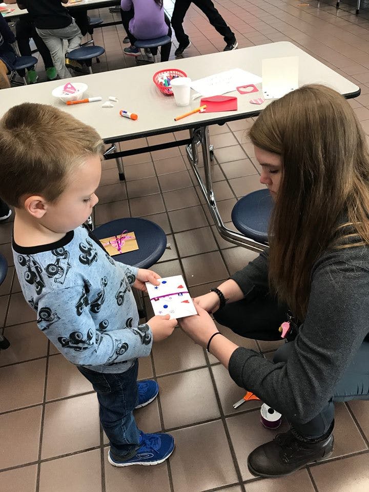 Adult and child holding a small decorated card