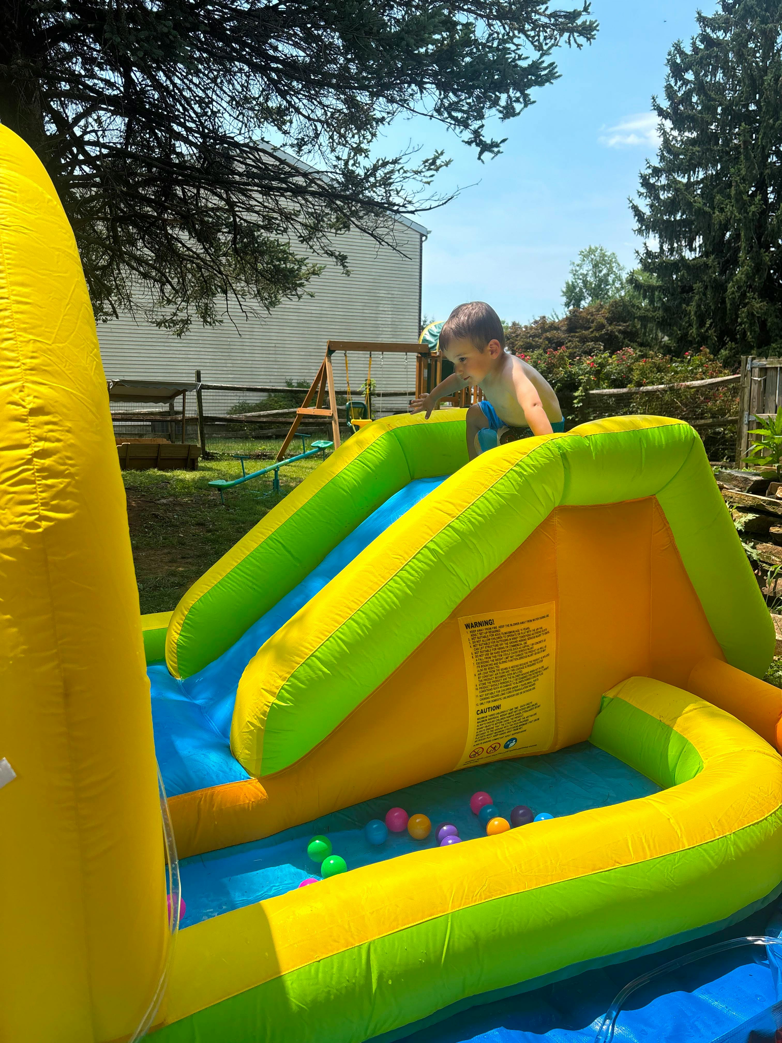 Child playing on an inflatable backyard slide