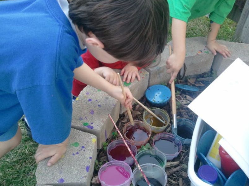 Children painting on concrete blocks with various colors