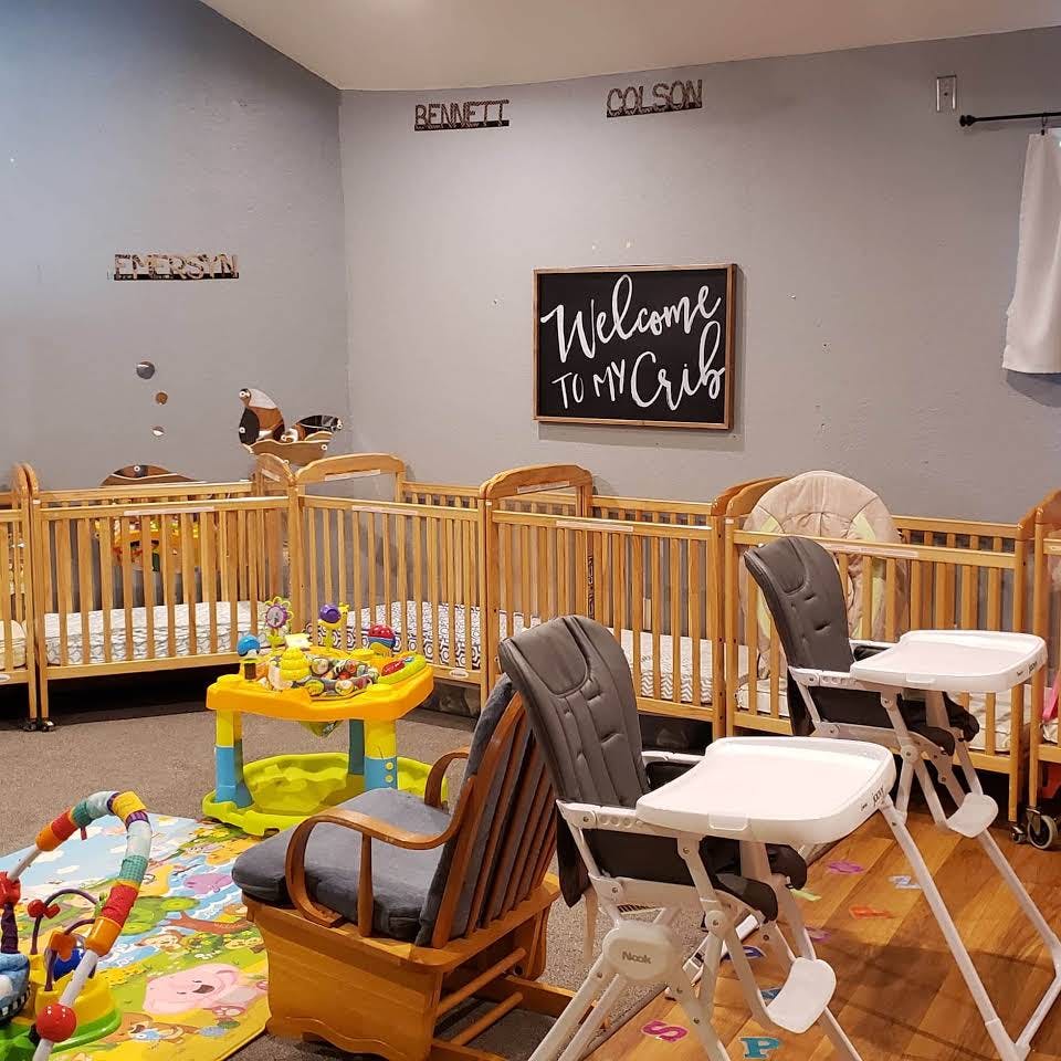 Room with multiple cribs, high chairs, and a play mat