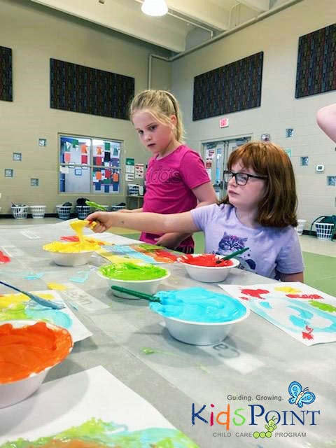 Two children painting at a table