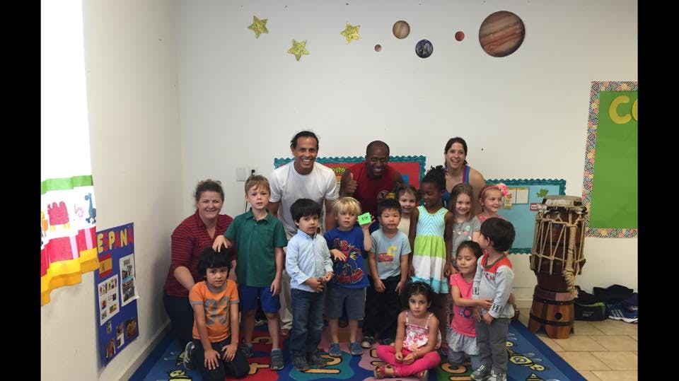 Group of adults and children posing in a classroom
