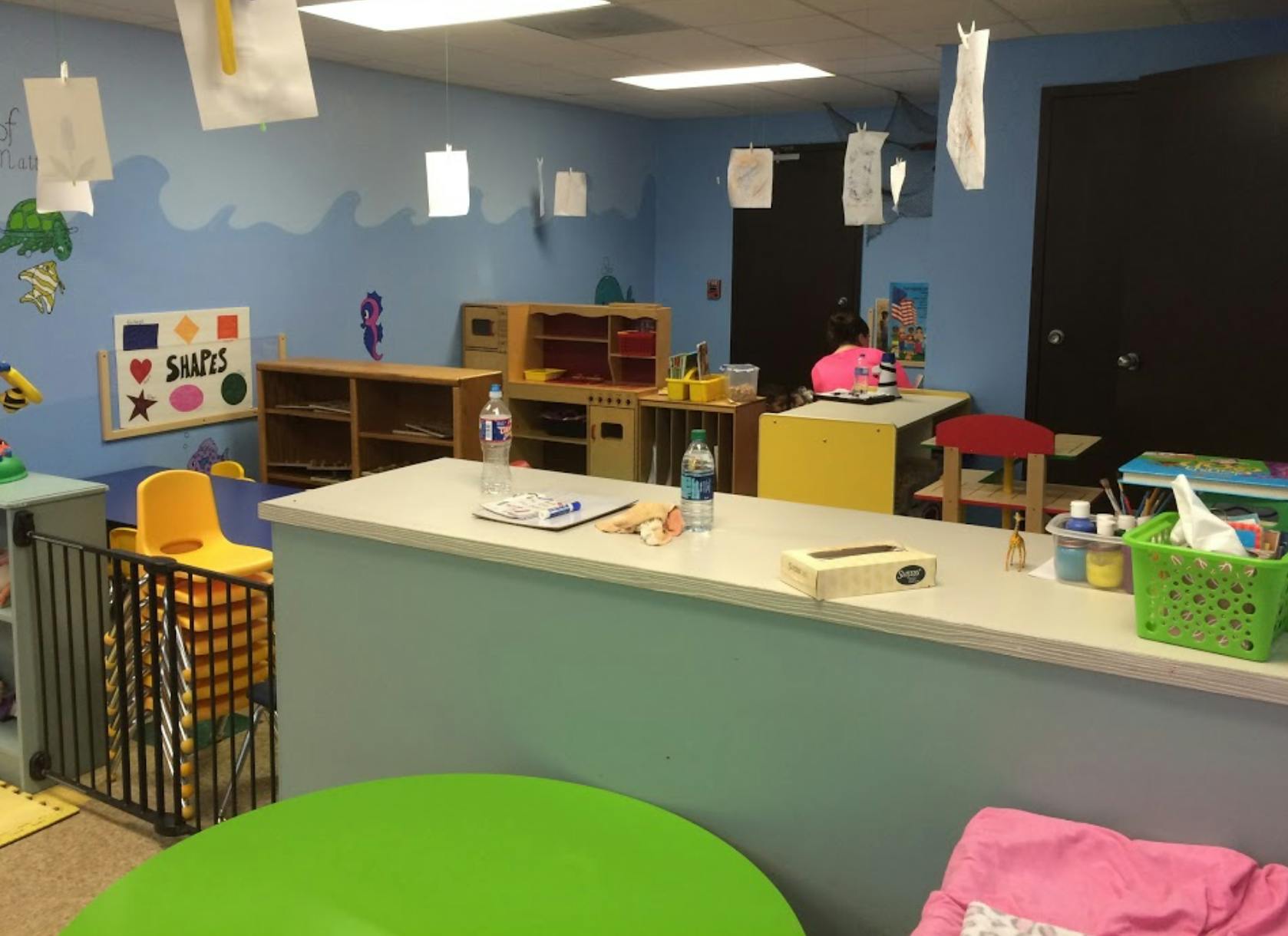 Classroom with blue walls, shelves, and a counter