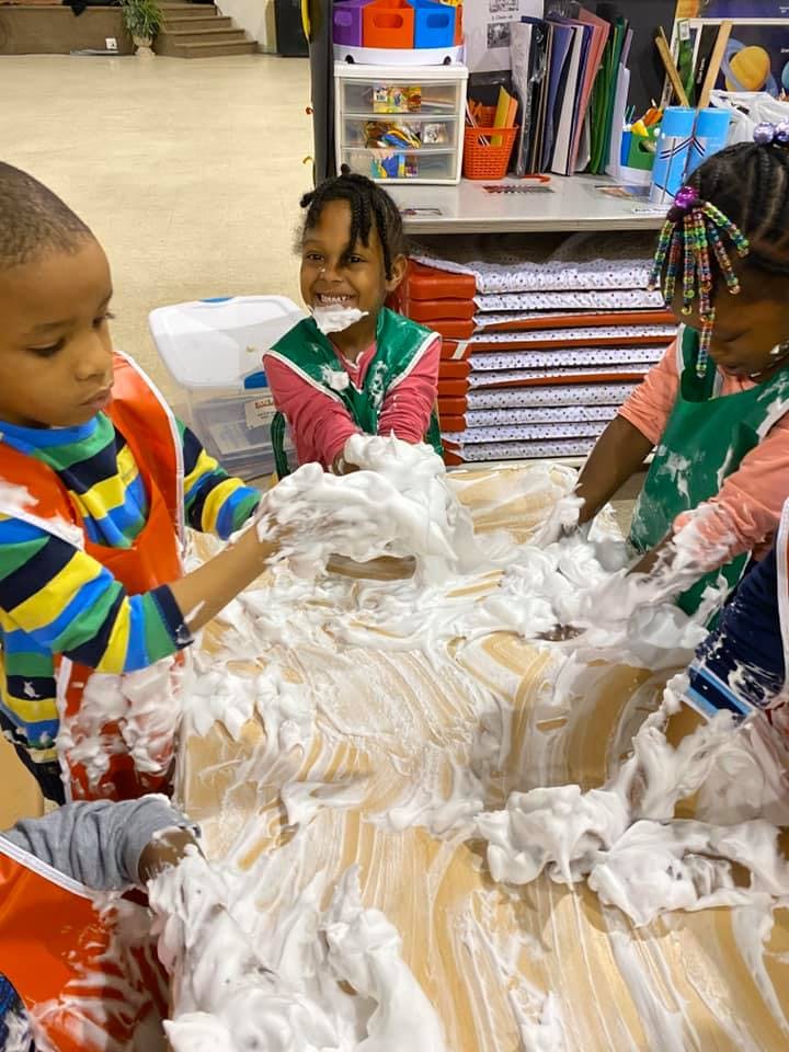 Children playing with shaving cream on a table