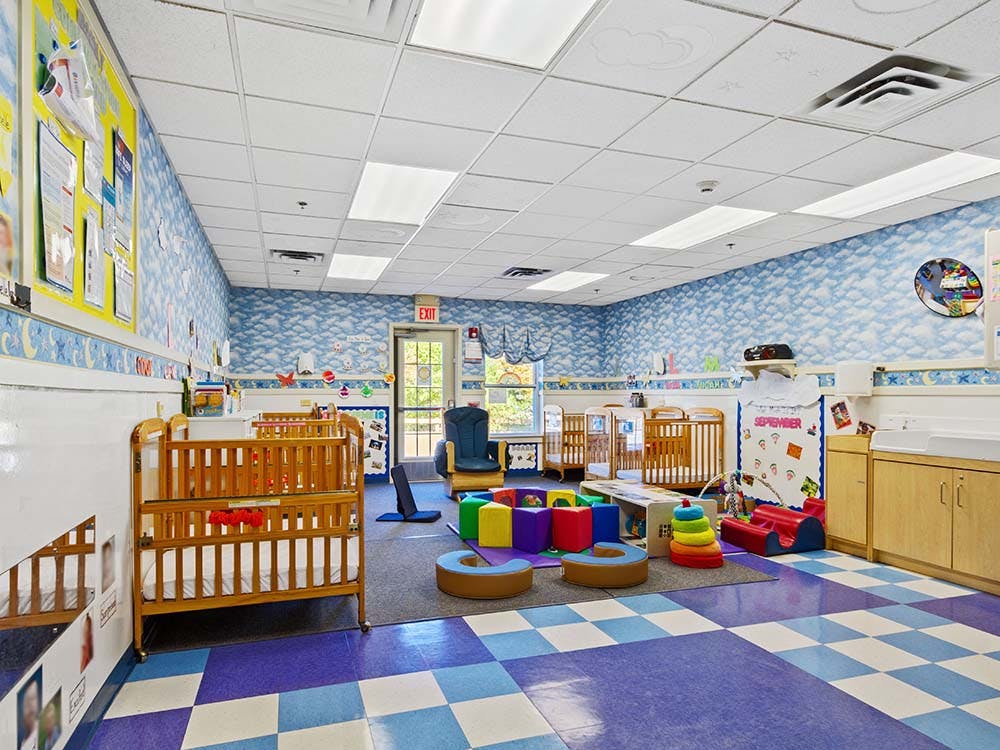 Empty colorful nursery room with cribs and play areas
