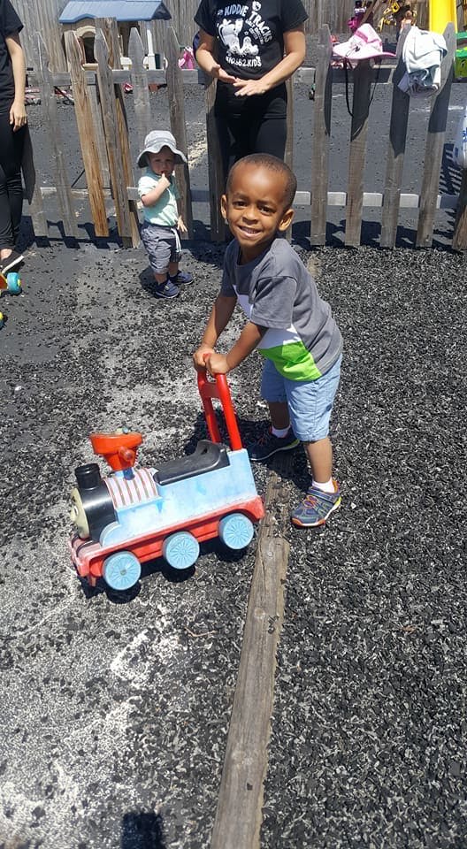 Child pushing a toy train on a playground
