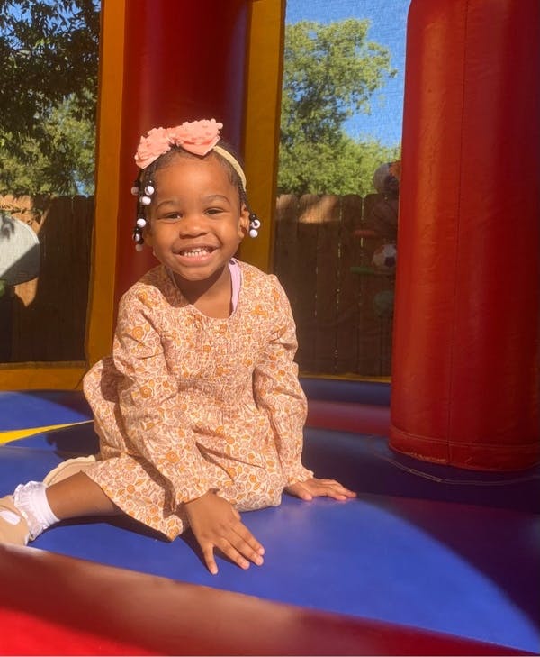 Child sitting in a bounce house