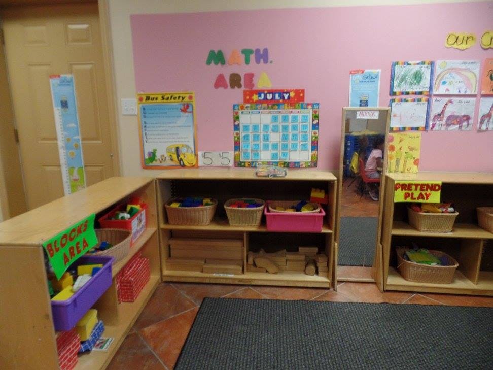 Classroom with shelves of toys and a pink wall with "MATH AREA" text