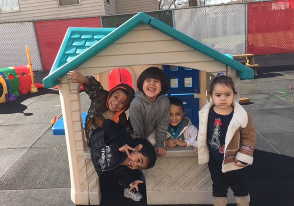 Children playing in and around a small playhouse