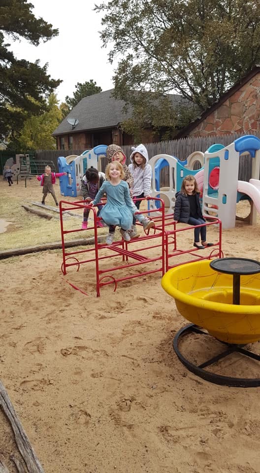 Children playing on playground equipment in a sandbox