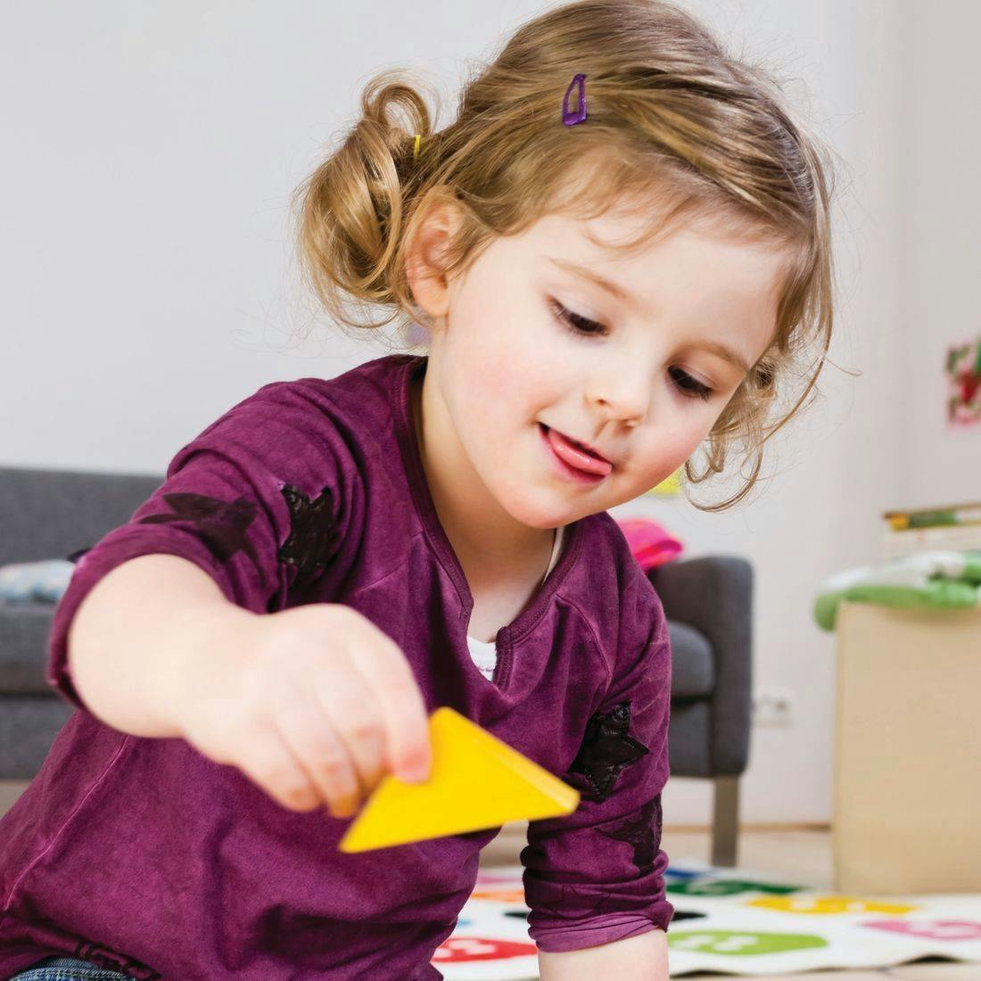 Child holding a yellow triangle shape
