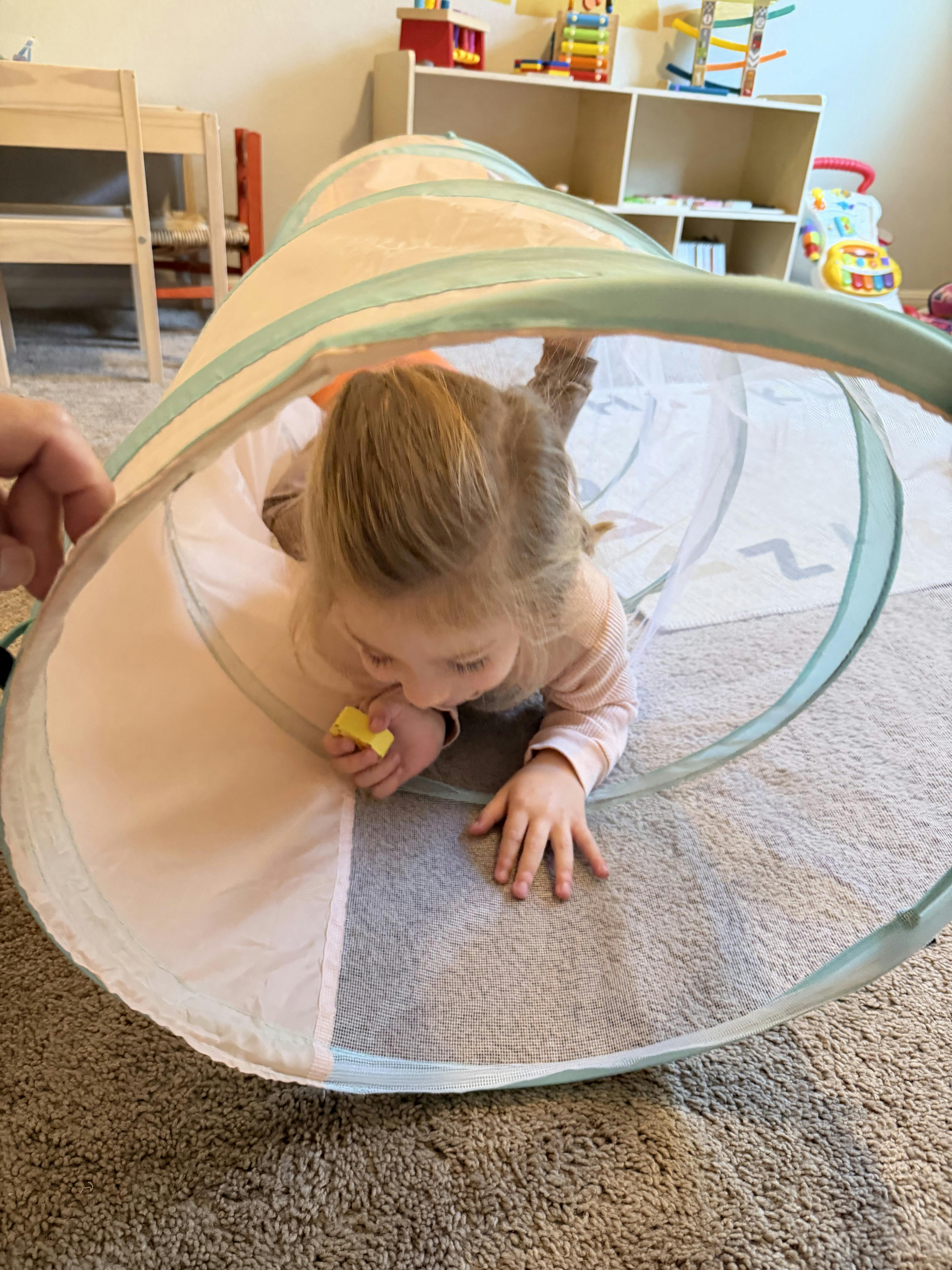 Child crawling through a play tunnel