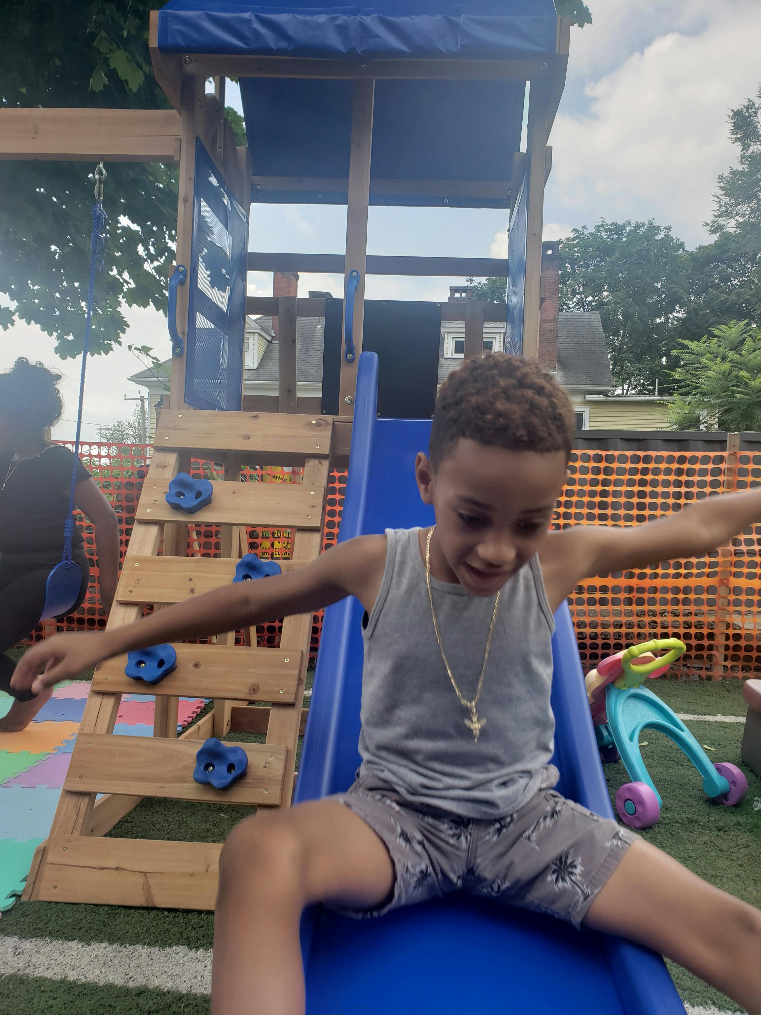 Child on a blue slide at a playground