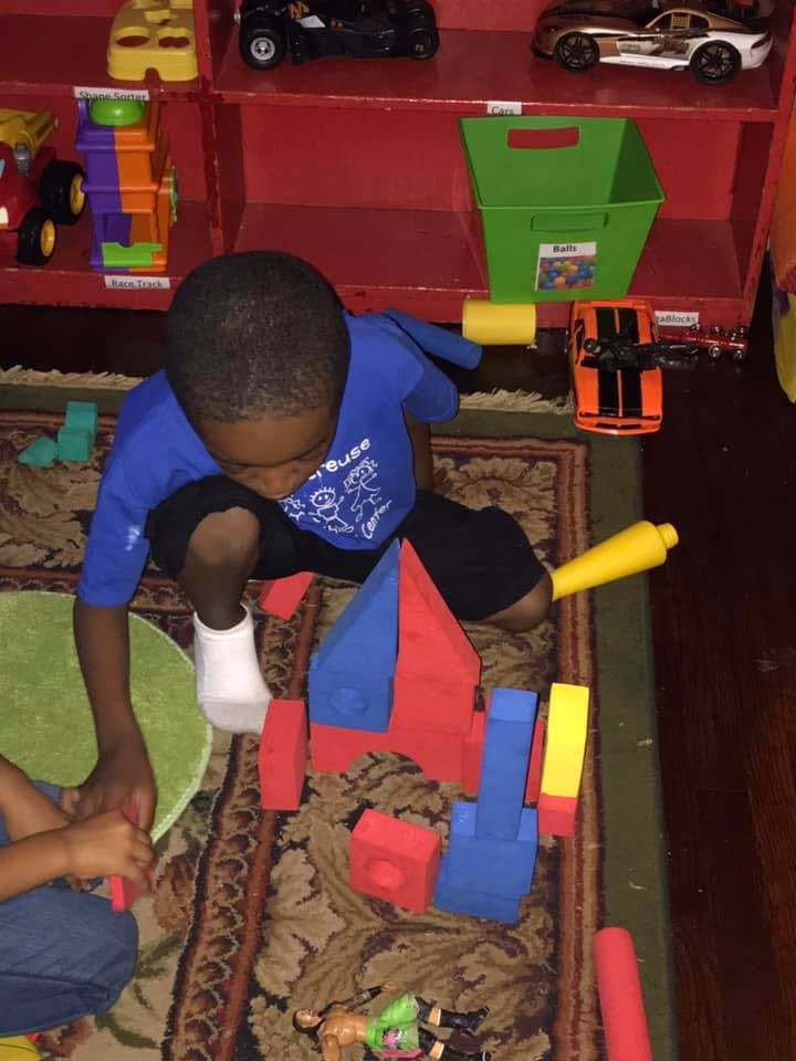 Child playing with building blocks on a rug