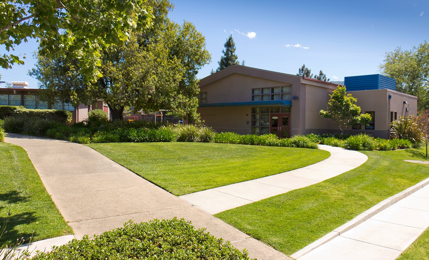 Building with a blue roof section and a path leading to it