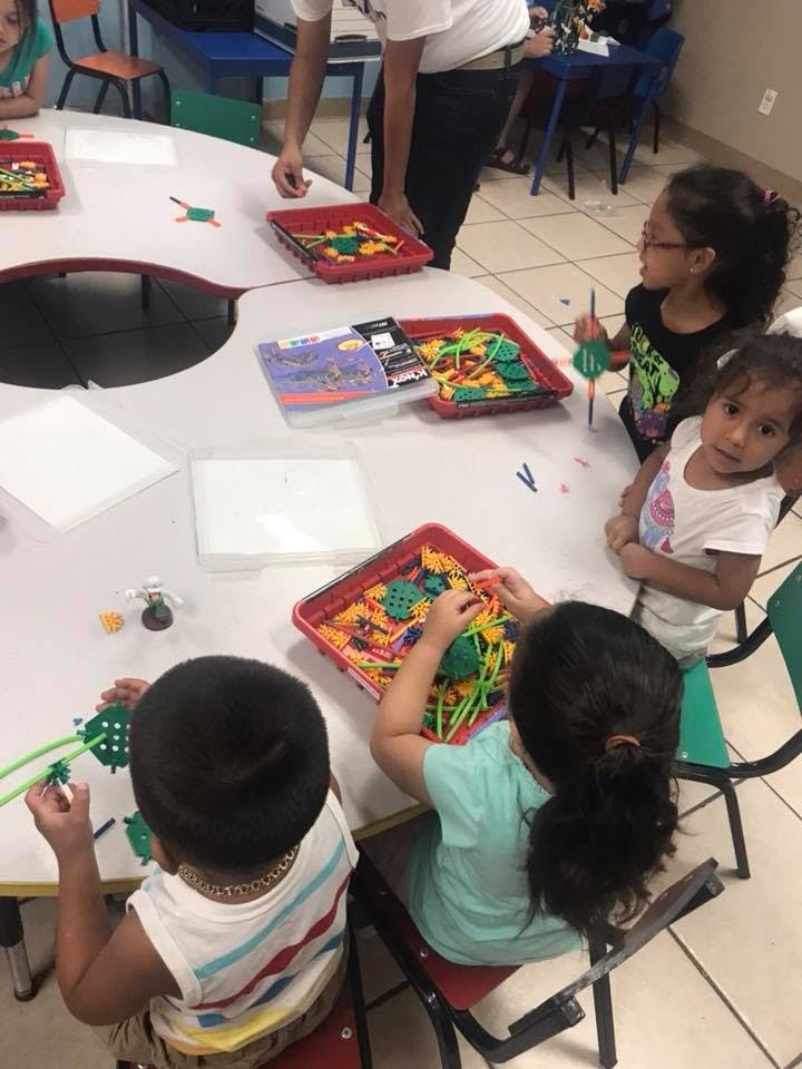 Children at a table playing with colorful building toys