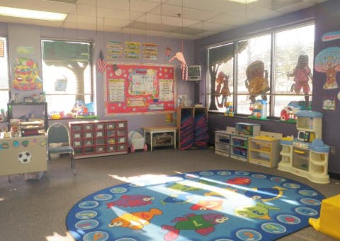 Empty classroom with a colorful rug and windows