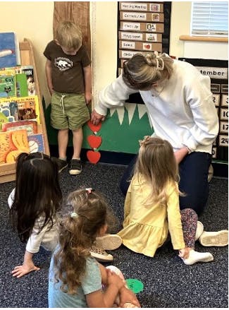 Adult and children in a classroom engaging with a learning activity