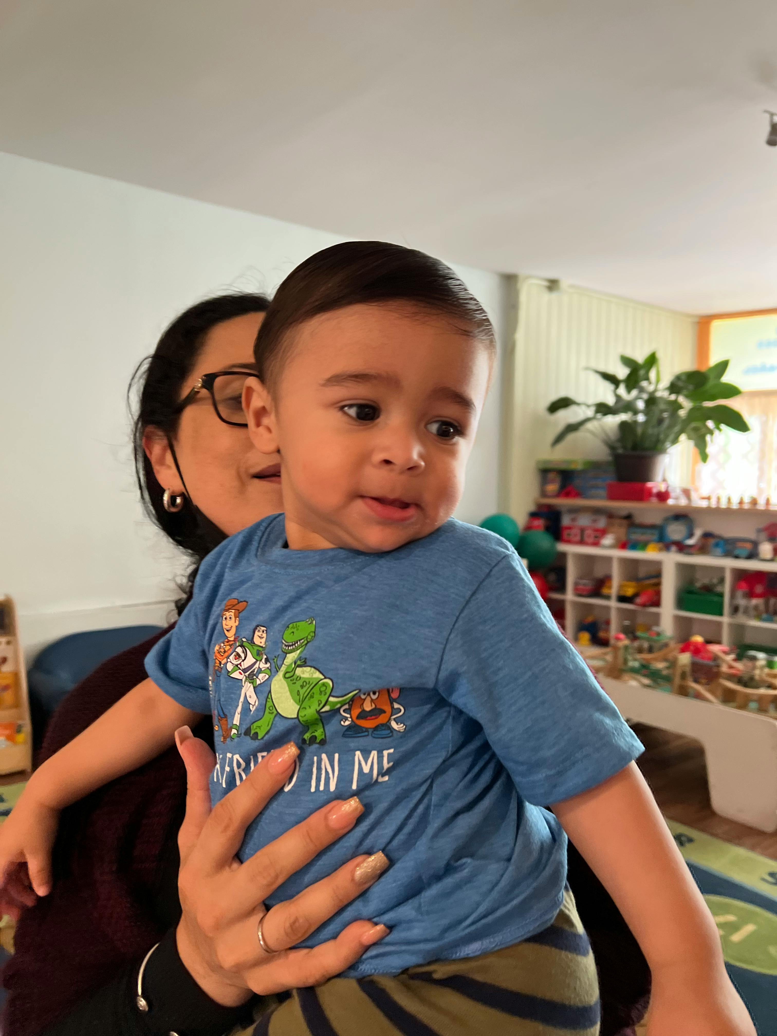 Person holding a child in a blue shirt