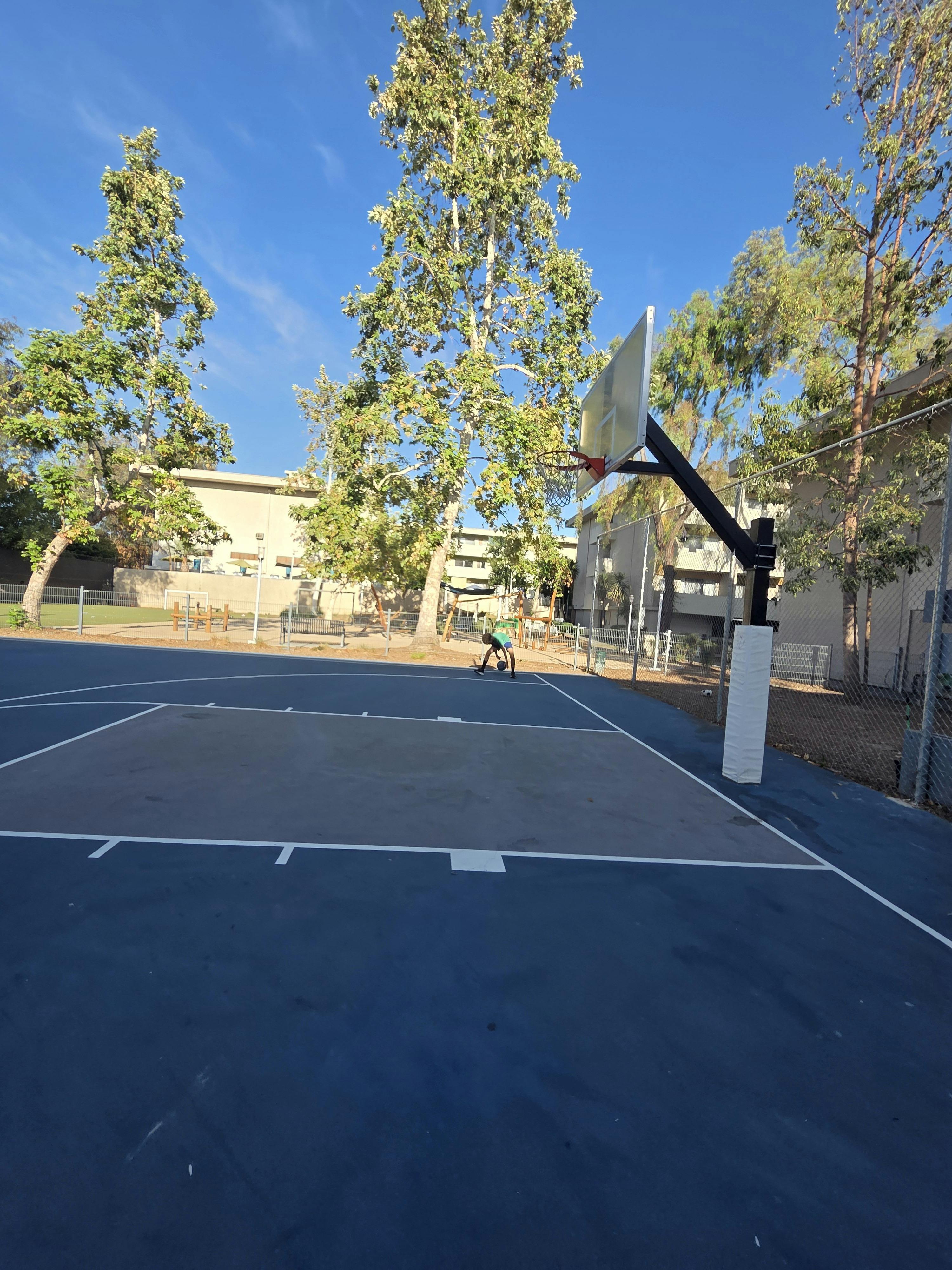 Person dribbling a basketball on an outdoor court