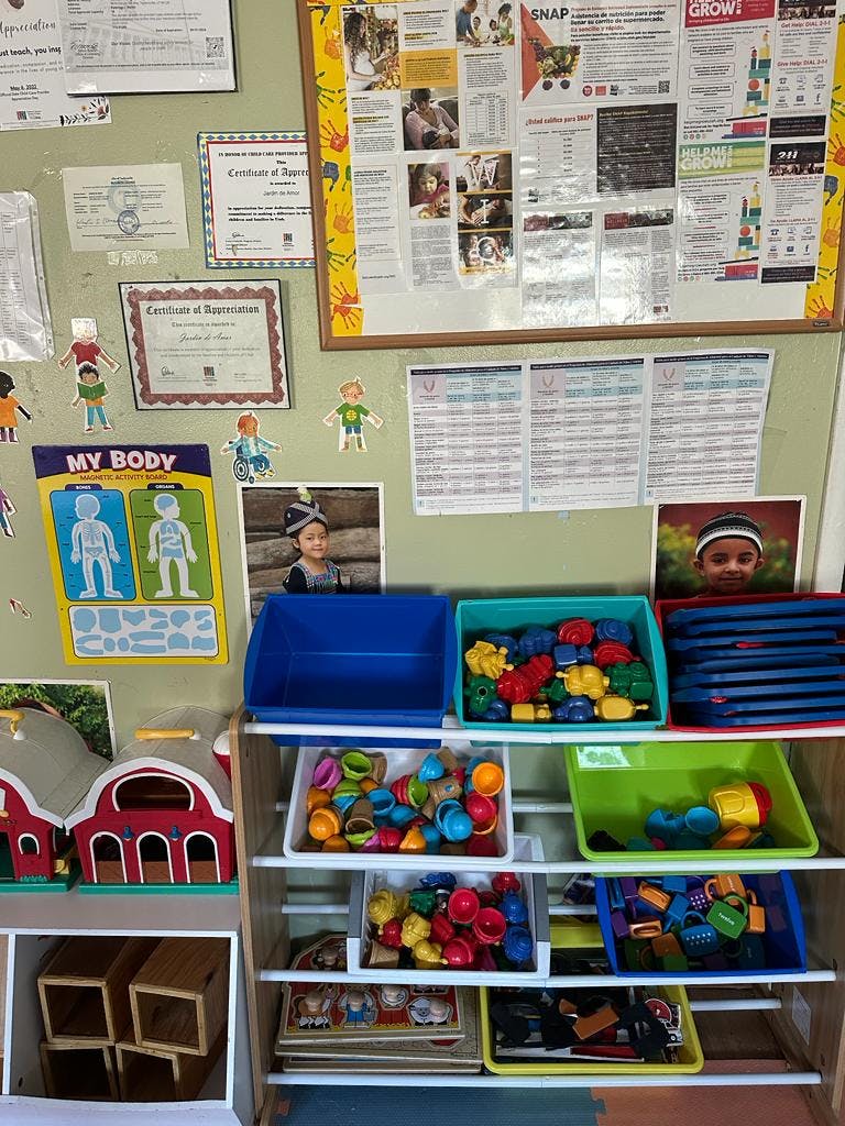 Wall with educational posters and shelves with toys and bins