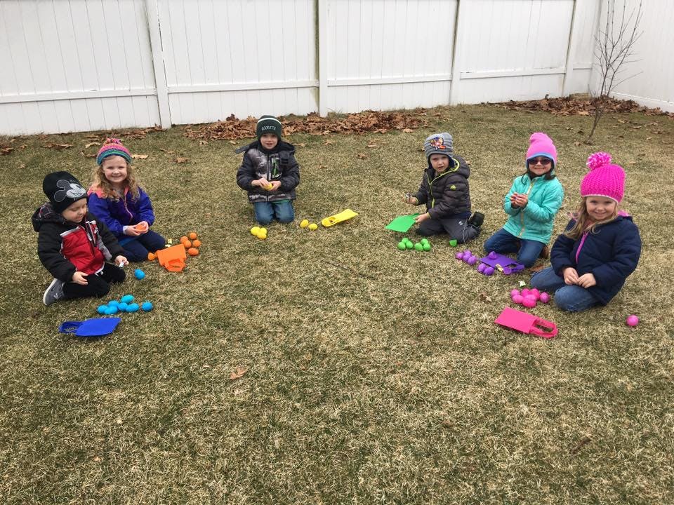 Six children playing with toys on grass