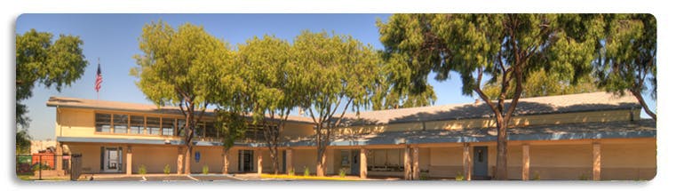 Building with trees in front and an American flag flying