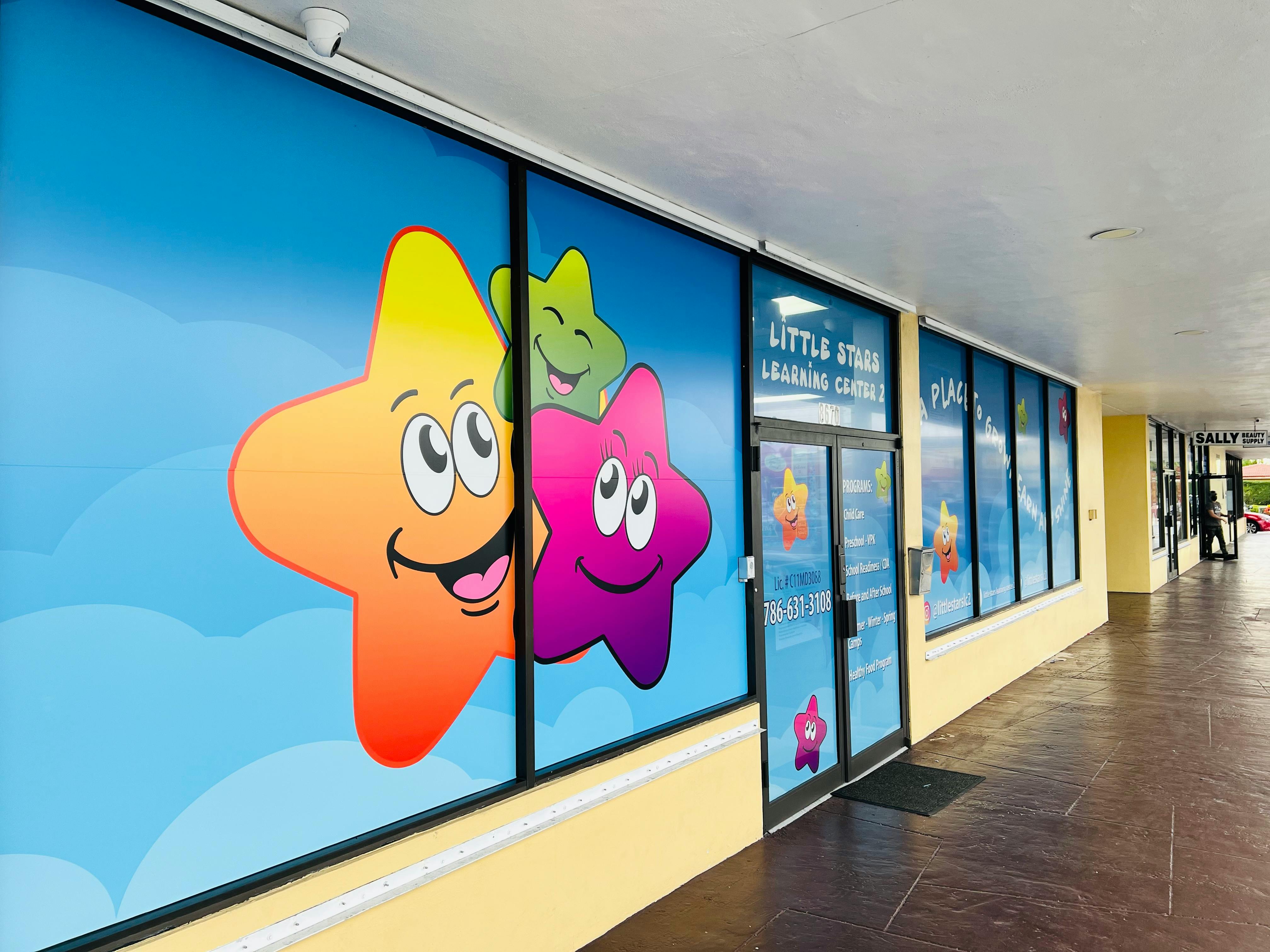 Storefront windows with cartoon stars and "Little Stars Learning Center" text