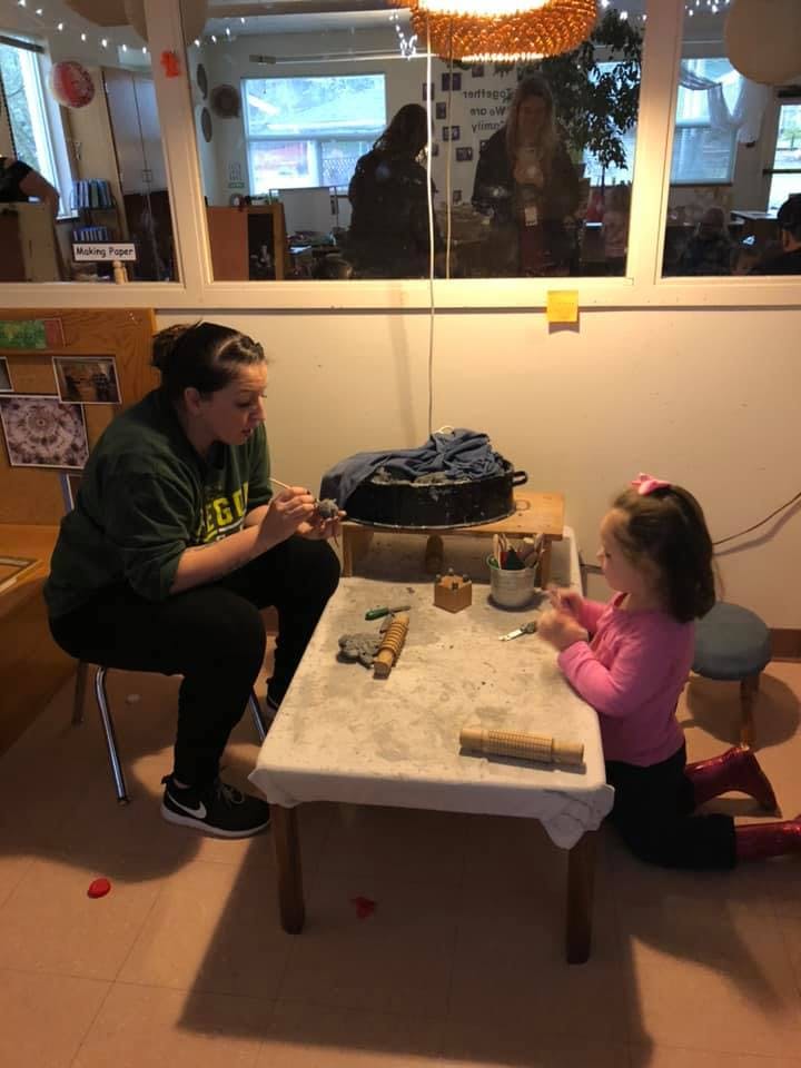 Adult and child sitting at a table doing an activity