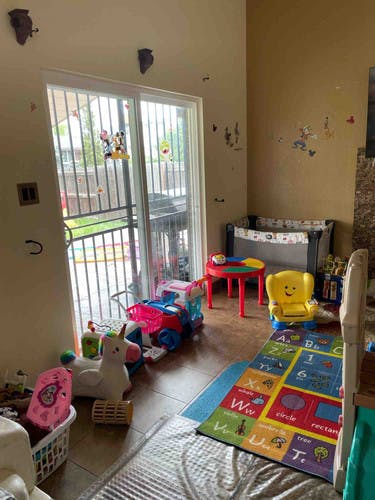 Playroom with toys, crib, and alphabet rug