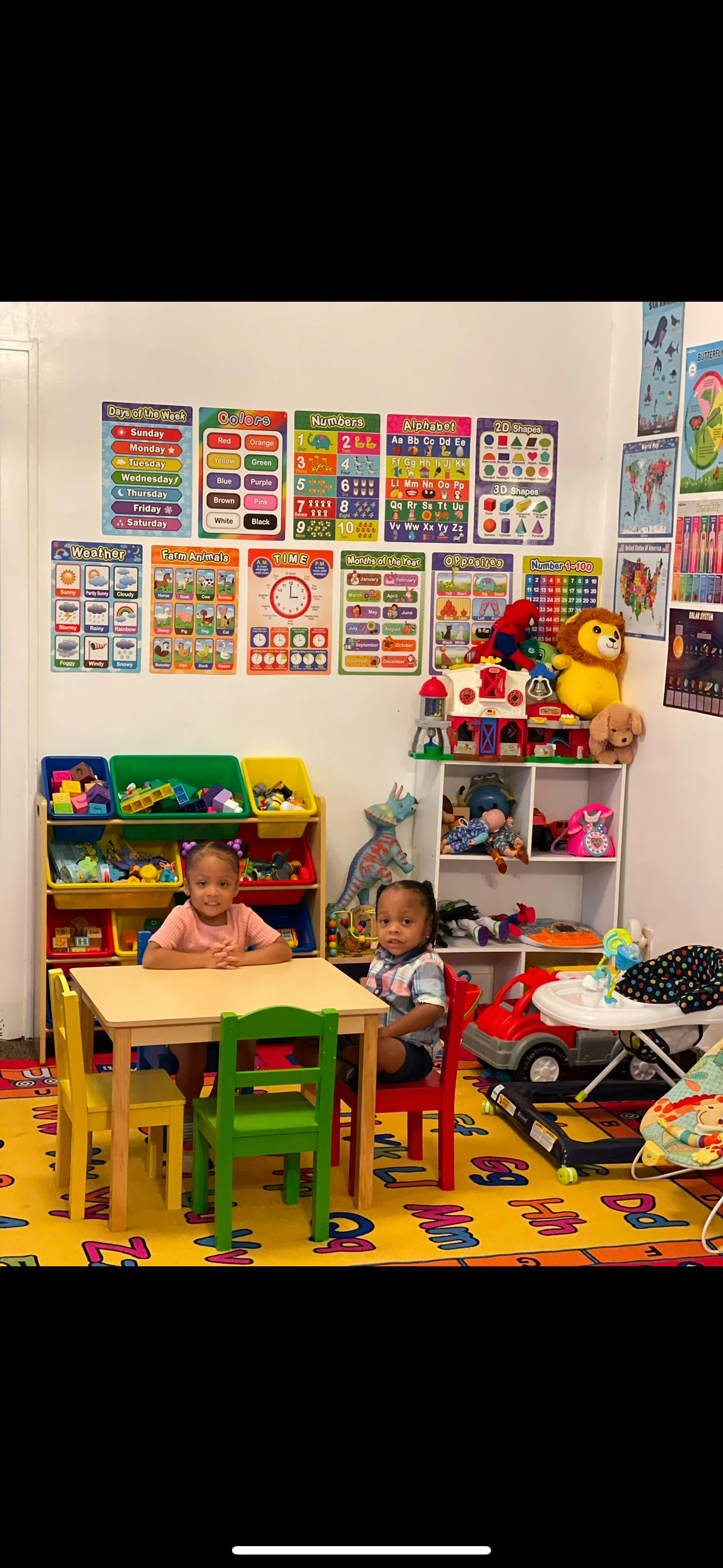 Two children sitting at a small table in a classroom