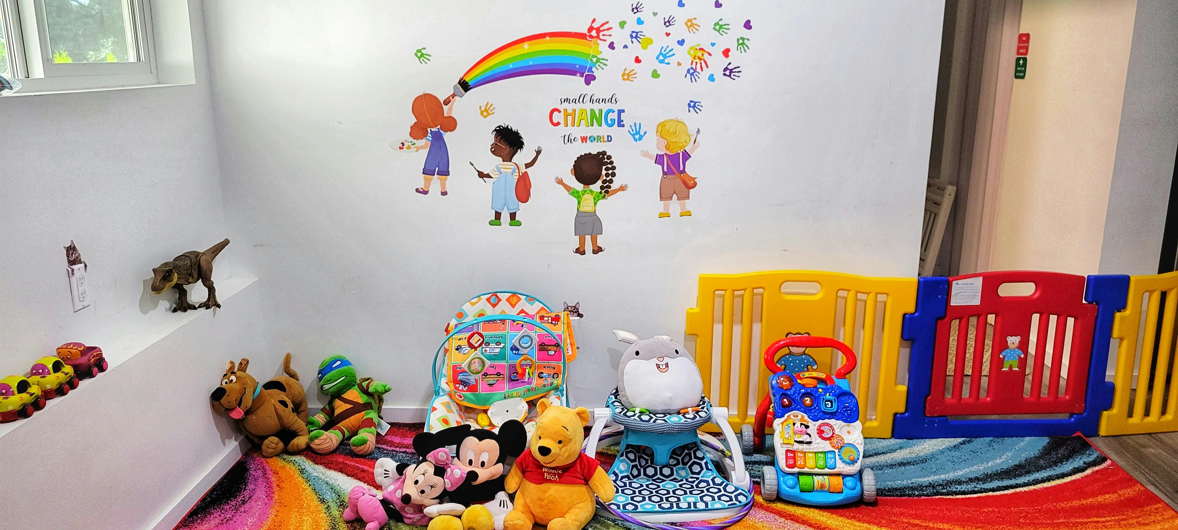 Children's playroom with wall decals, stuffed animals, and toys