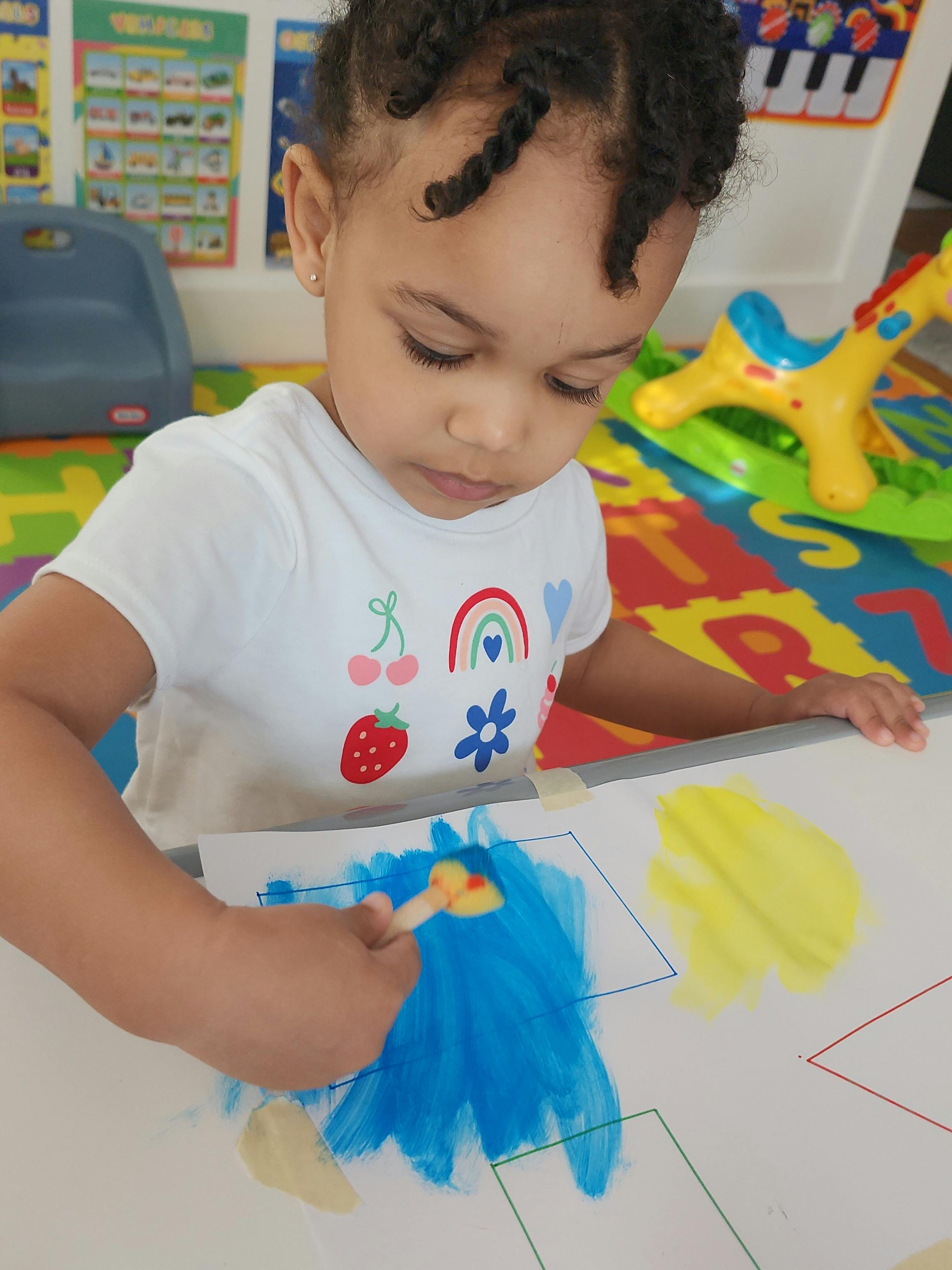 Child painting on an easel with a sponge brush