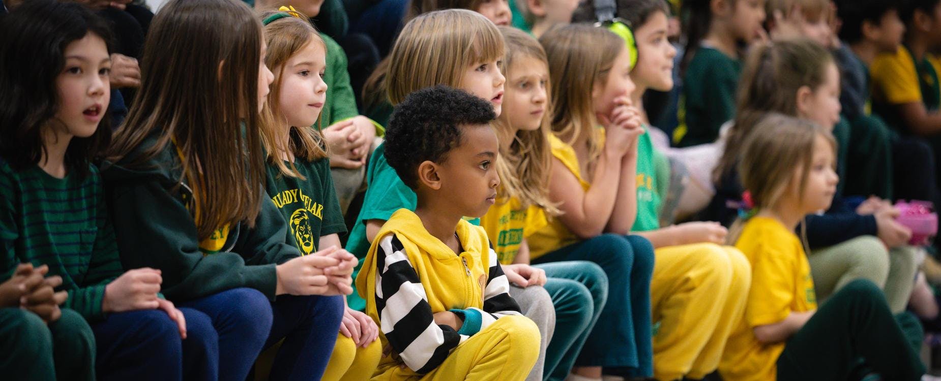 Children sitting in rows, looking forward