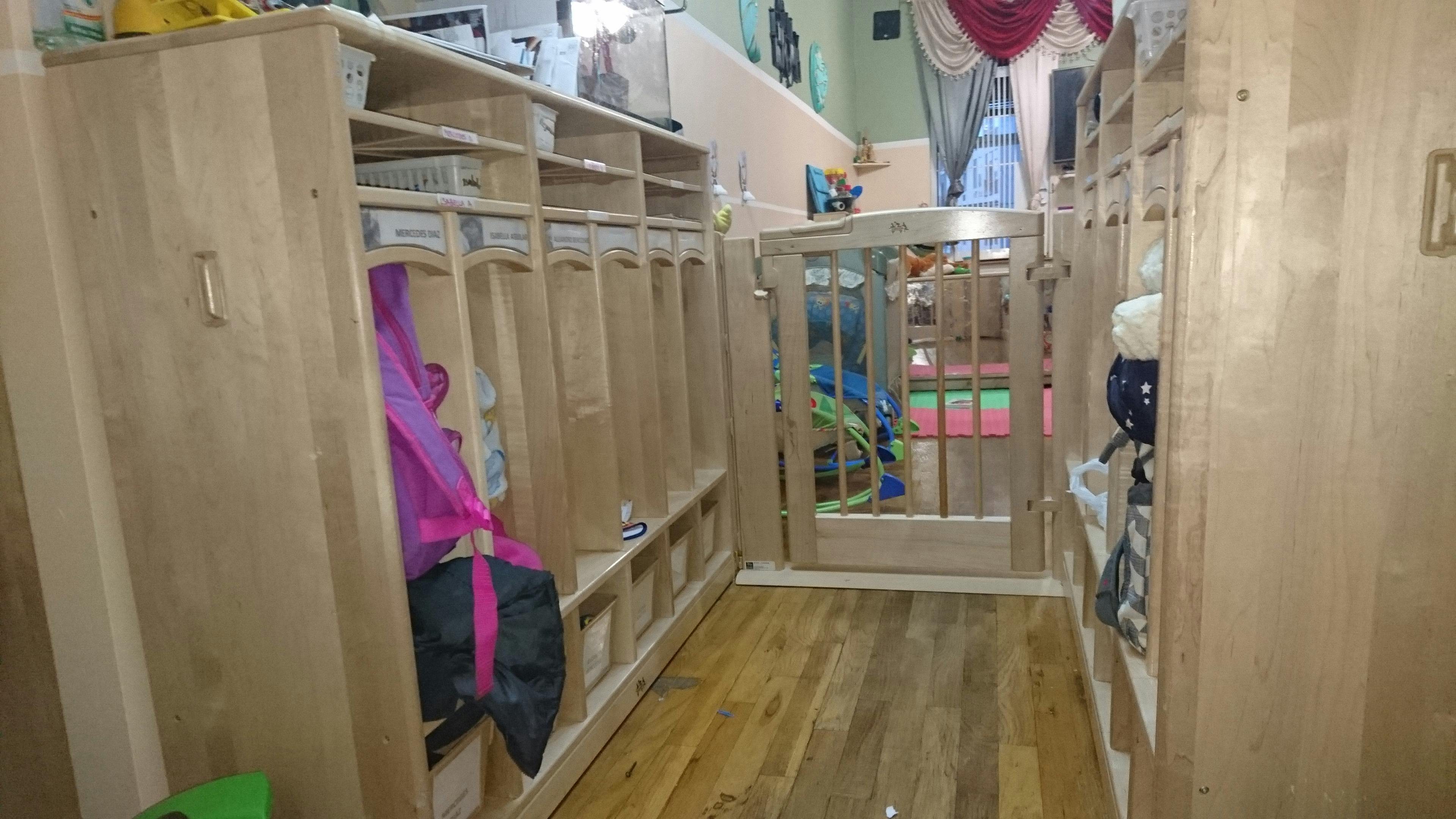 Row of wooden cubbies with a gate leading to another room