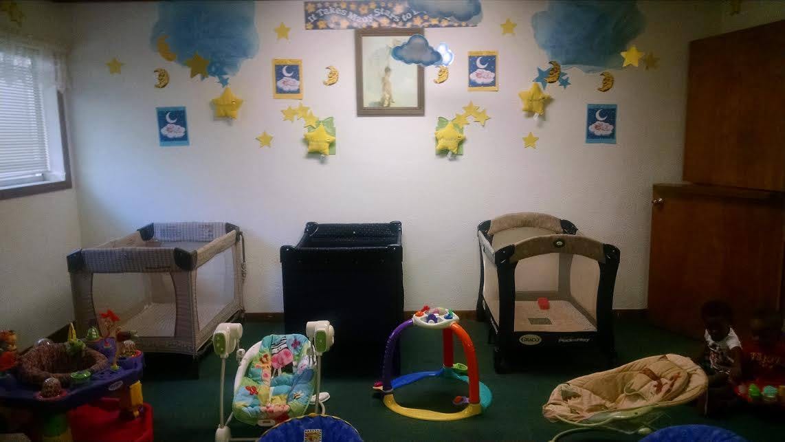 Nursery room with three cribs and baby play items