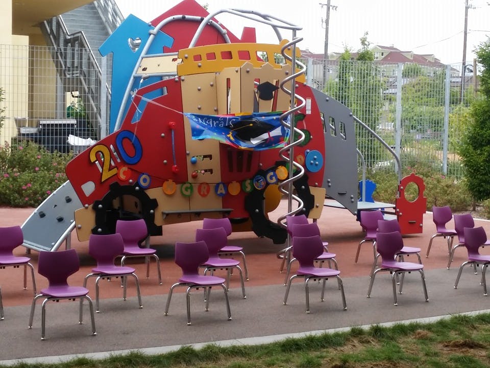 Purple chairs arranged in front of a colorful playground structure