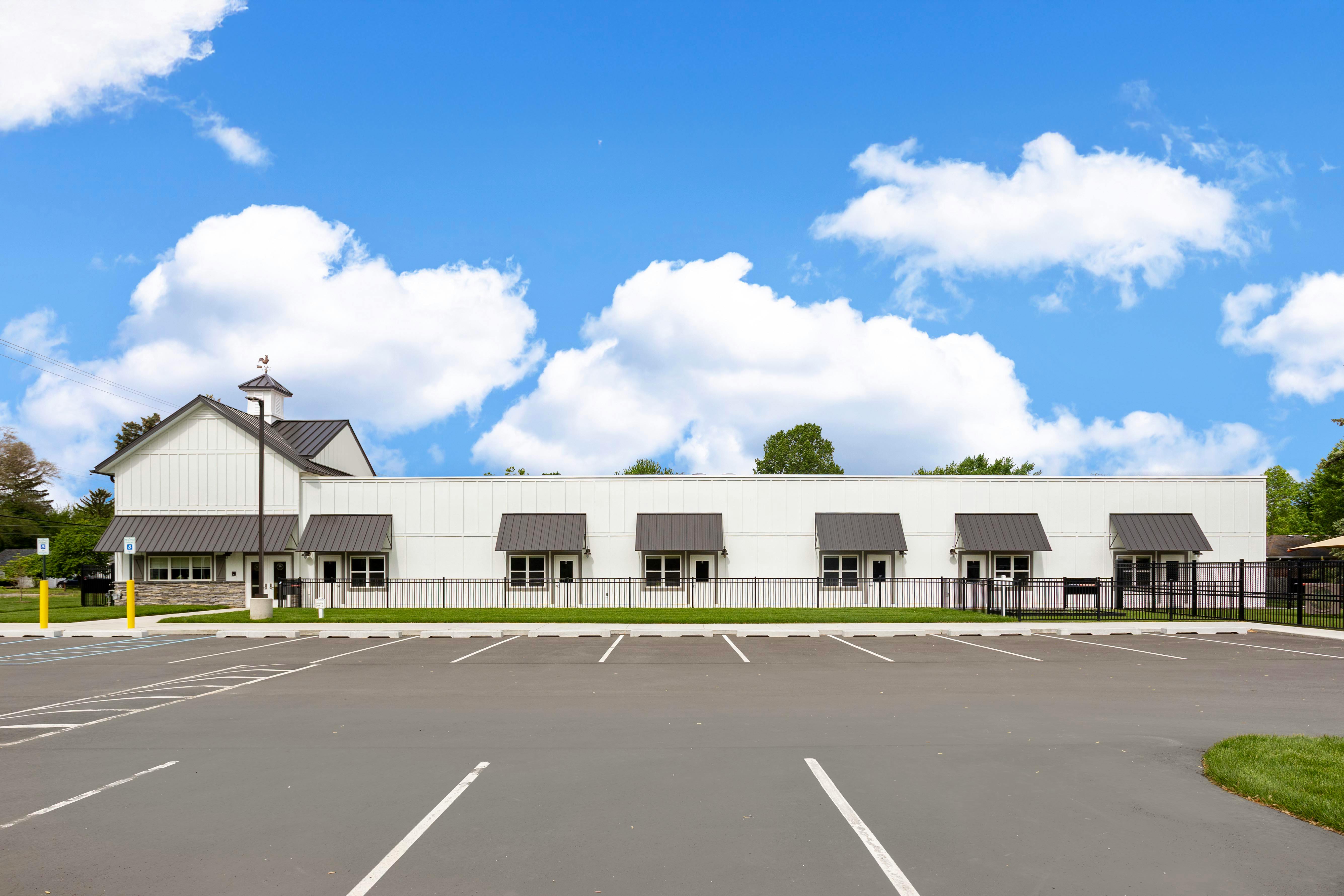 White building with a parking lot in front