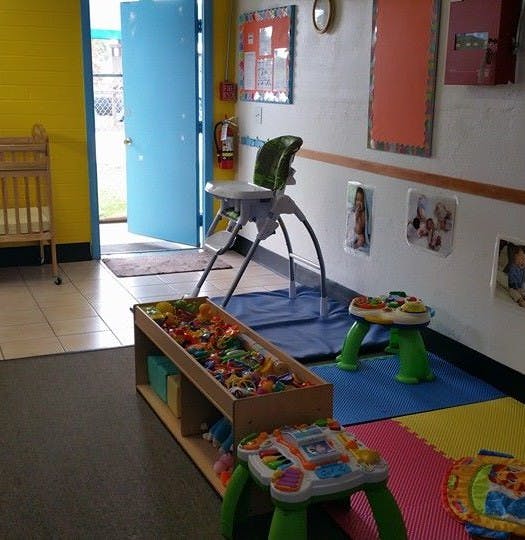 Childcare room with high chair, crib, and toys