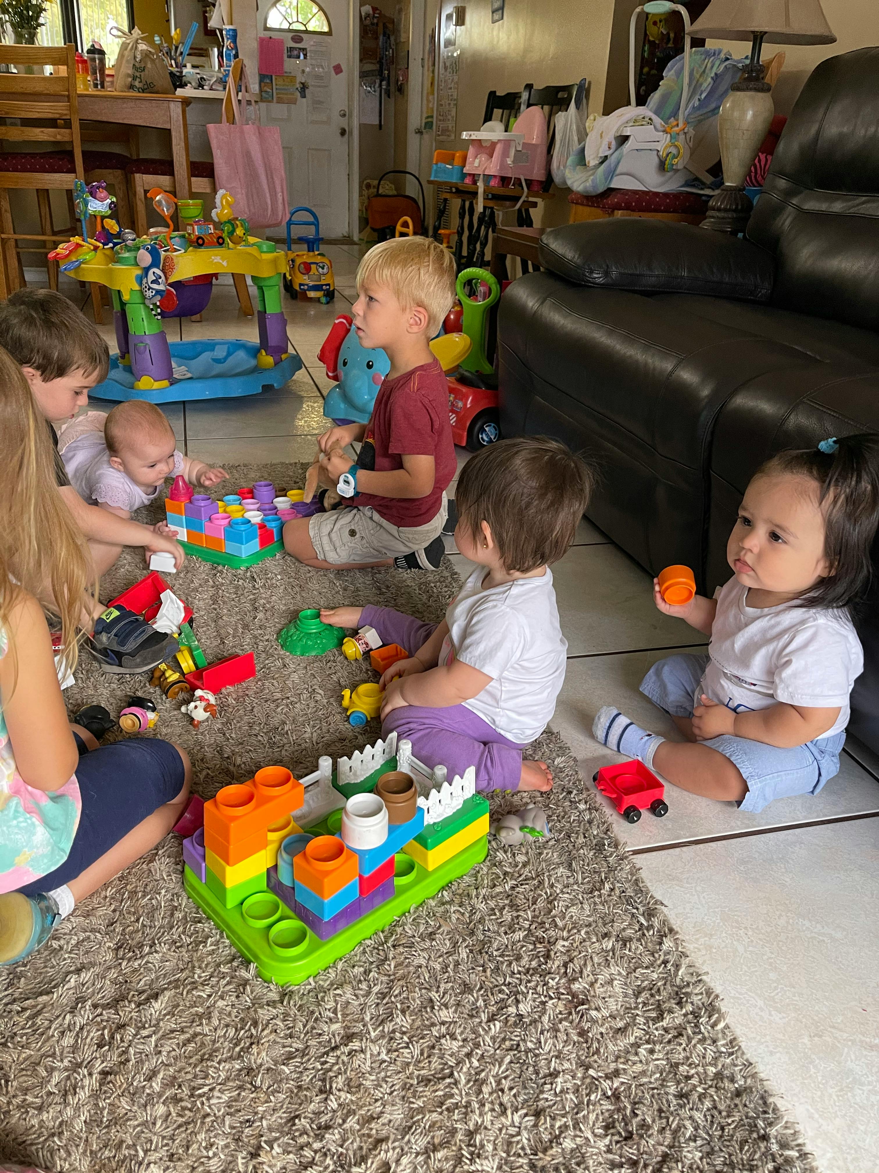 Multiple children playing with toys on a rug
