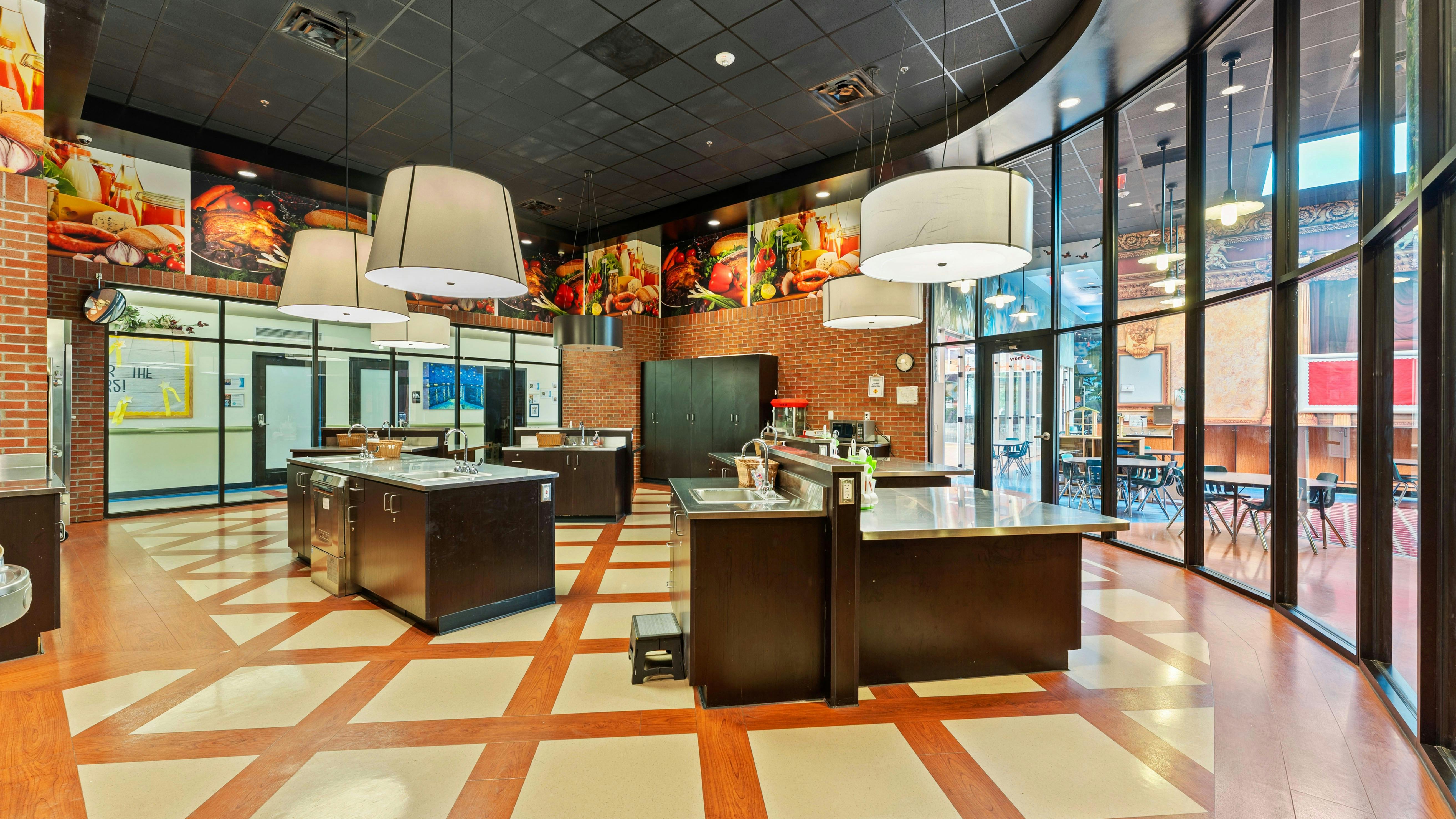 A culinary classroom with several cooking stations and large windows