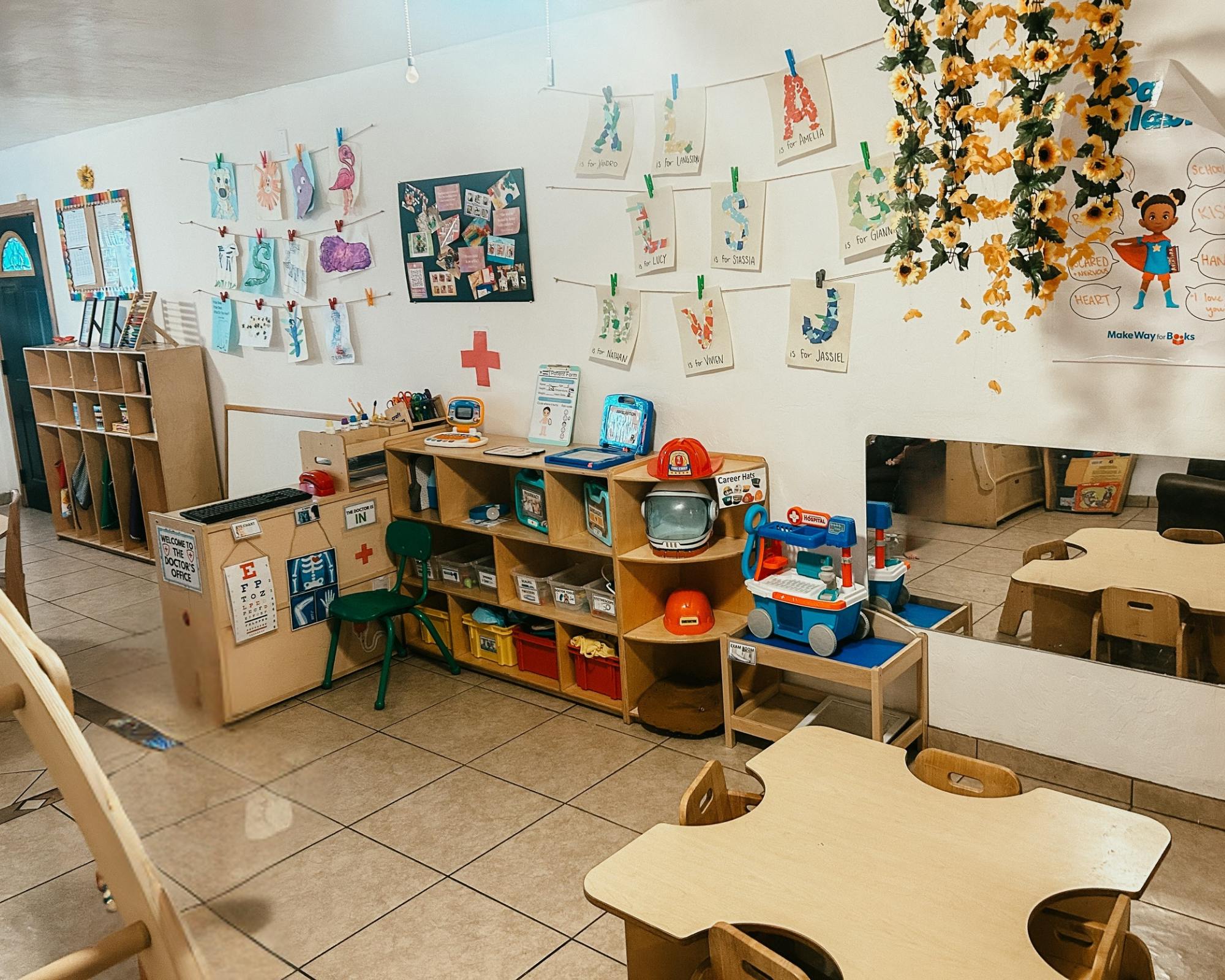 Classroom with shelves of toys, tables, and artwork on the walls