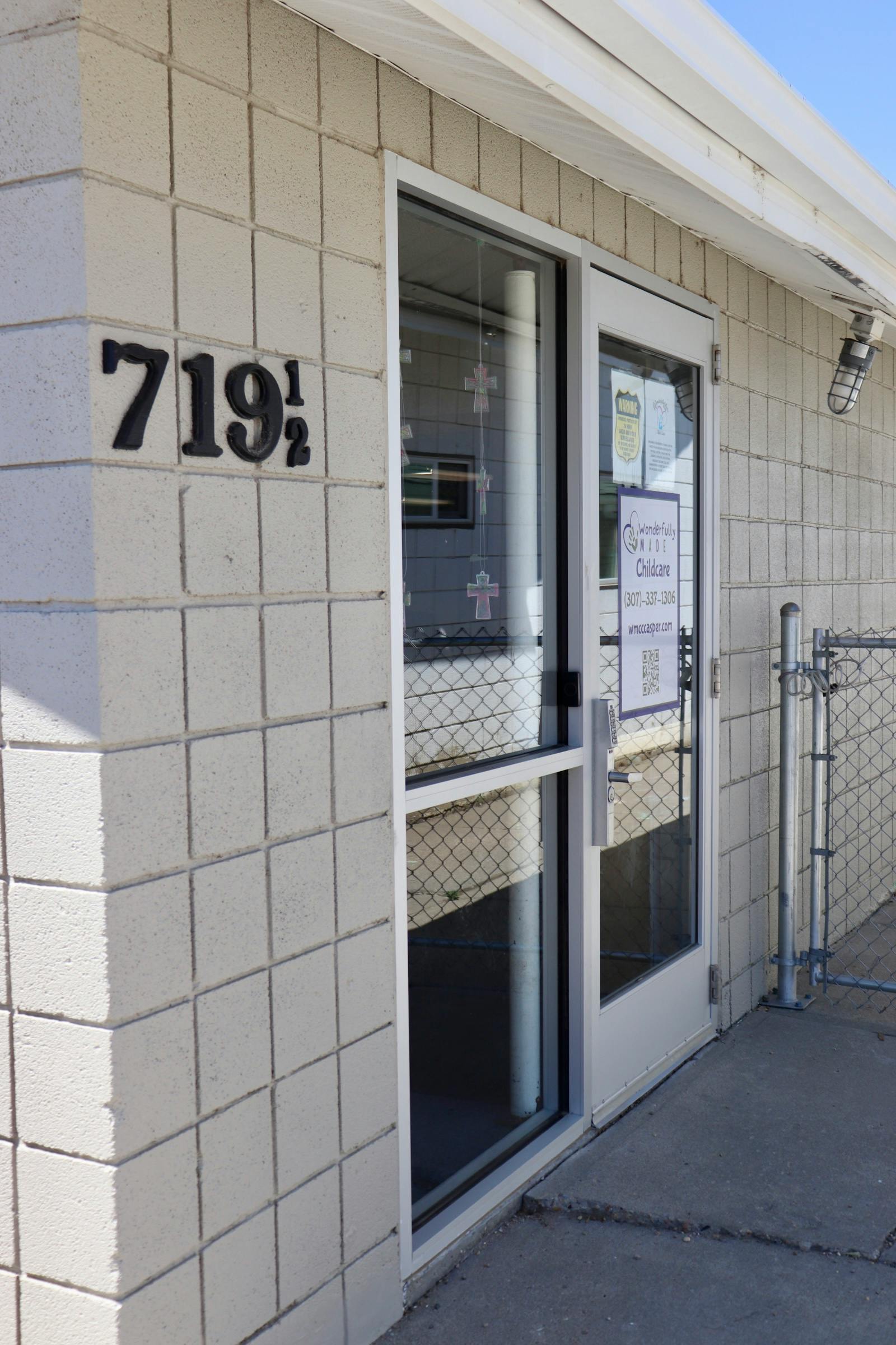 Entrance to a building with "719 1/2" on the wall and a "Childcare" sign on the door