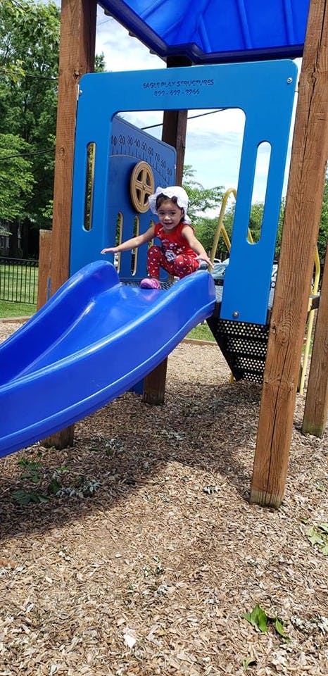 Child on a blue playground slide
