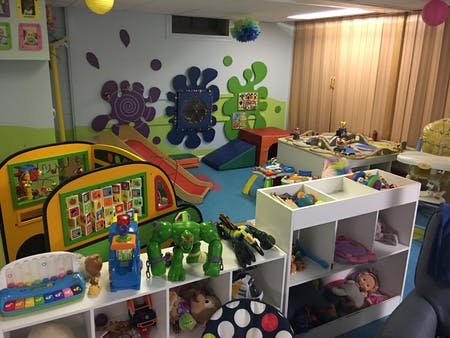Playroom with toys, a slide, and colorful wall decorations