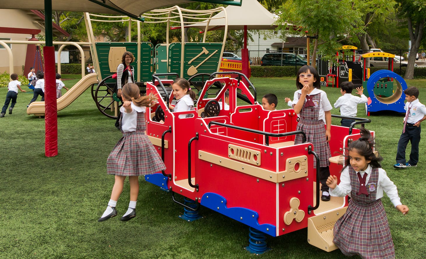 Children playing on a red train-shaped playground structure