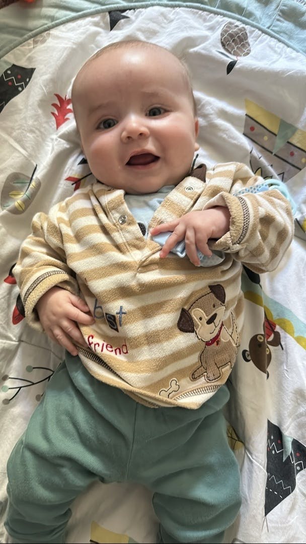 Baby lying down, wearing striped top with dog graphic and "best friend" text
