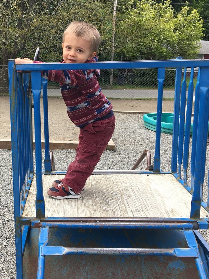 Child standing on a blue playground structure
