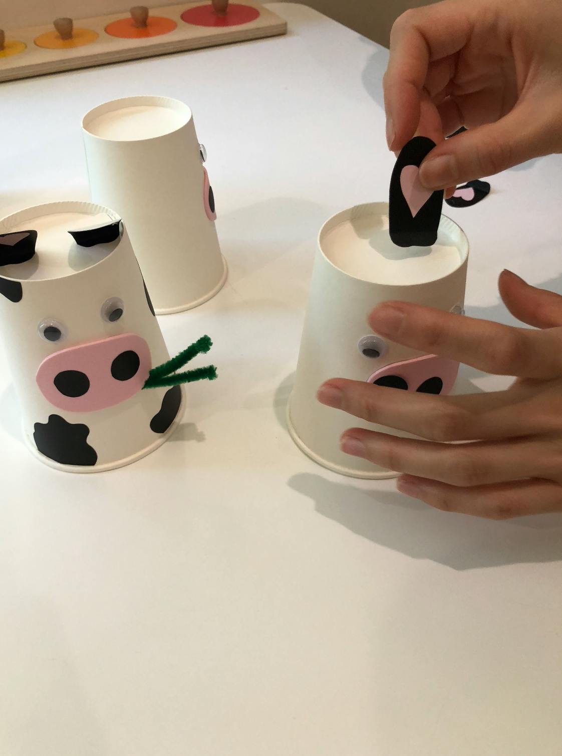 Person making a cow craft from a paper cup