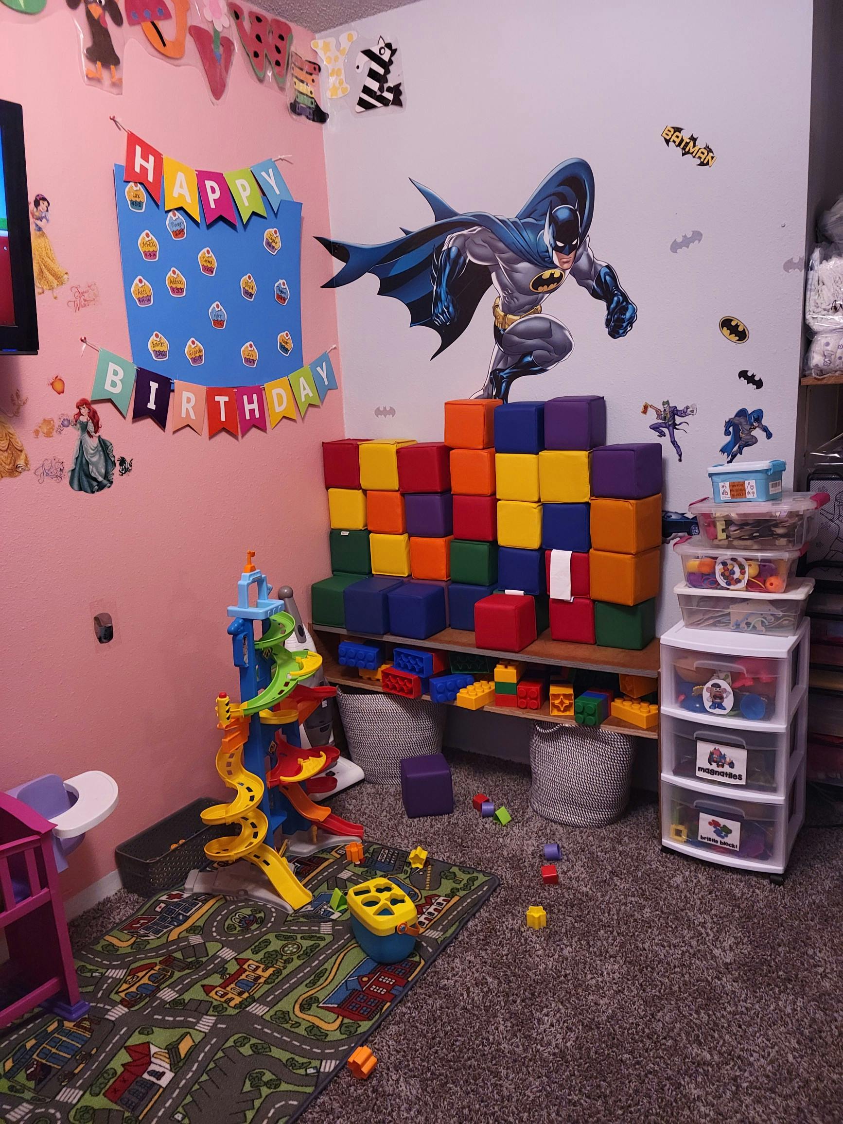 Child's room with Batman wall decal, colorful blocks, and toys